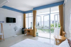 a room with a bed and a desk and a window at Tâm An Hotel in Nhơn Trạch