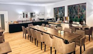 a restaurant with a long table and chairs at Mertinkus Nordseehotel in Cuxhaven