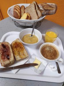 a plate of food with bread and a bowl of soup at Premiere Classe Limoges Nord in Limoges