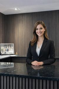 a woman in a suit sitting at a desk at Mertinkus Nordseehotel in Cuxhaven
