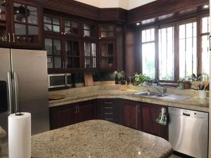 a kitchen with wooden cabinets and a white refrigerator at Villa de Dos Armadillos in Santa Maria Huatulco