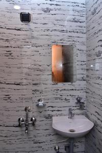 a bathroom with a sink and a mirror on the wall at HOTEL SSK PRIME in Vijayawāda