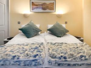 a bed with two pillows on top of it at Paddy's Cottage in Flookburgh