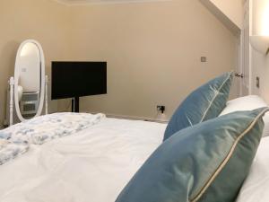 a bedroom with a bed with a mirror and a tv at Paddy's Cottage in Flookburgh +9 photos