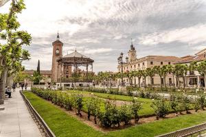 a garden in front of a building with a clock tower at El Pontifical in Los Santos de la Humosa