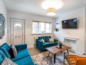 a living room with a blue couch and a table at Woods Terrace in Gainsborough