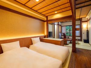 a room with two beds and a desk in a room at Mori no yu Kira No Sato Reopening on December 22, 2025 in Ito +72 photos