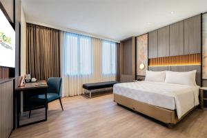 a hotel room with a bed and a desk at Swiss-Belexpress Jemursari in Surabaya