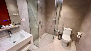 a bathroom with a shower and a toilet and a sink at W Suites Hotel Sama Abha in Abha