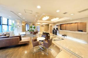 an office lobby with a couch and tables and chairs at Yokohama Mandarin Hotel in Yokohama