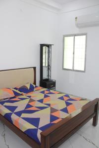 a bedroom with a bed with a colorful quilt on it at Anand Lodge in Thiruchendur +43 photos
