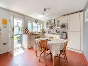 a kitchen with a table and chairs in it at Glendower in Aberaeron +15 photos