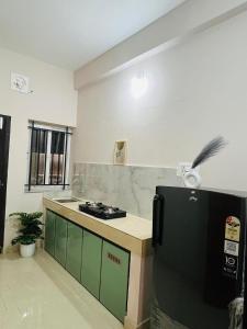 a kitchen with a black refrigerator in a room at City Creek in Perintalmanna