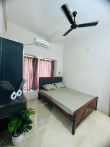 a bedroom with a bed and a ceiling fan at City Creek in Perintalmanna