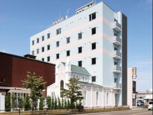 a white building with a church in front of it at Kurayoshi City Hotel in Kurayoshi