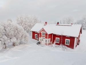 a red house in the snow with trees at Lapland Heritage Villa in Ranua +46 photos