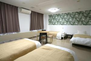 a hotel room with two beds and a table at HOTEL Reise Basis ホテルライゼベイシス in Senboku