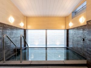an indoor swimming pool in a room with a window at Kurayoshi City Hotel in Kurayoshi