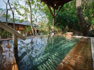 a swimming pool in a resort with trees at Mori no yu Kira No Sato Reopening on December 22, 2025 in Ito