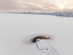 a round hole in a snow covered field at Lapland Heritage Villa in Ranua