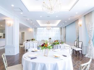 a room with white tables and chairs and a chandelier at Kurayoshi City Hotel in Kurayoshi +47 photos