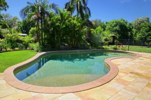 a swimming pool in a yard with a patio at Salamander Bay Bed and Breakfast in Salamander Bay