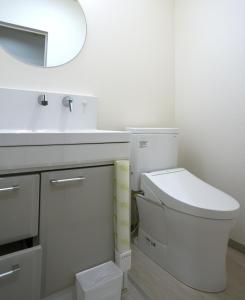 a bathroom with a toilet and a sink and a mirror at HOTEL Reise Basis ホテルライゼベイシス in Senboku