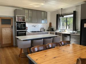 a kitchen with a wooden table and chairs and a counter at Fortuna views farm stay in Jumbuk