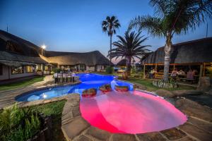 ein großer Pool mit rotem Becken in einem Resort in der Unterkunft Cest Si Bon Hotel in Otjiwarongo