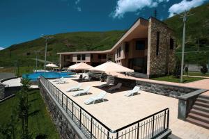 a building with a patio with chairs and a pool at Sevan Up In in Aghk'ilisa