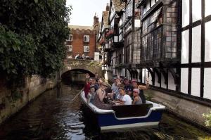 a group of people riding in a boat down a canal at The idyllic Acorn Lodge in Canterbury +3 photos