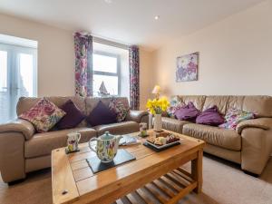 a living room with a couch and a coffee table at Bwthyn Hudol - Uk46711 in Pwllheli