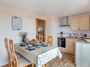 a kitchen with a table with a table cloth on it at Bwthyn Hudol - Uk46711 in Pwllheli