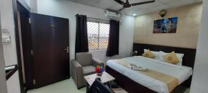 a bedroom with a bed and a chair and a window at hotel silver fountain in Jāmb