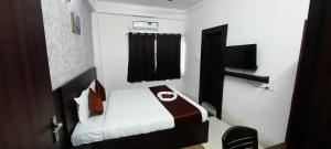 a small room with a bed and a television at hotel silver fountain in Jāmb