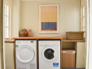 a laundry room with a washer and dryer in it at Coachmans Close in Milverton +22 photos