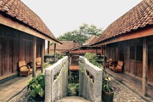 a walkway between two buildings with tables and chairs at Omahe Kancaku in Balong
