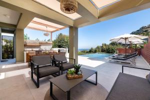 an outdoor living room with a view of the ocean at Cicada Villa in Koskinou