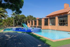 a swimming pool with a slide in front of a building at San Lameer Villa 2002 in Southbroom