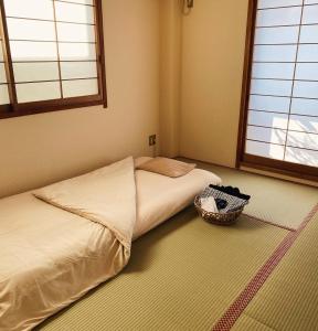 a bedroom with a bed and a basket on the floor at 春日旅館-Kasuga Ryokan- in Nabari