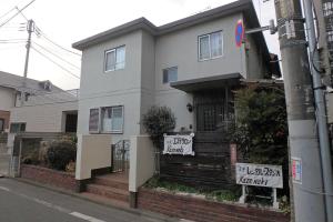 a white house with signs on the front of it at KazenoKi in Kichijōji