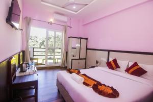 a bedroom with two beds and a window at Amazon Resort in Sauraha