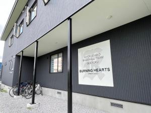 a building with a sign on the side of it at バーニングハーツ in Asahikawa