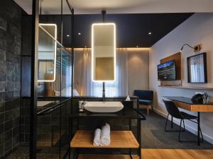 a bathroom with a sink and a shower at Century City Hotel Bridgewater in Cape Town +55 photos
