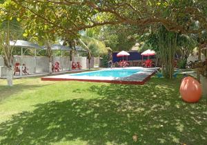 a swimming pool in a yard with a tree at Mutary II in Santa Cruz Cabrália +4 photos