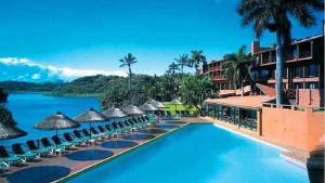 a pool at a resort with umbrellas and the water at San Lameer Villa 2002 in Southbroom