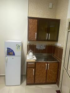 a small kitchen with a sink and a refrigerator at العييري للشقق المخدومة حائل 3 in Hail