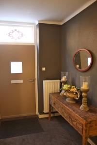 a room with a table with candles and a mirror at Abeelboom B and B in Middelburg