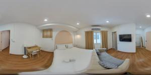 a large white room with a couch and a tv at Marshmallow House in Sathani Lak Si