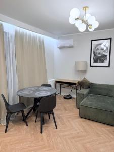 a living room with a table and a couch at Kapitańska Przystań - basen & sauna & jacuzzi & klimatyzacja & garaż in Dziwnów +14 photos